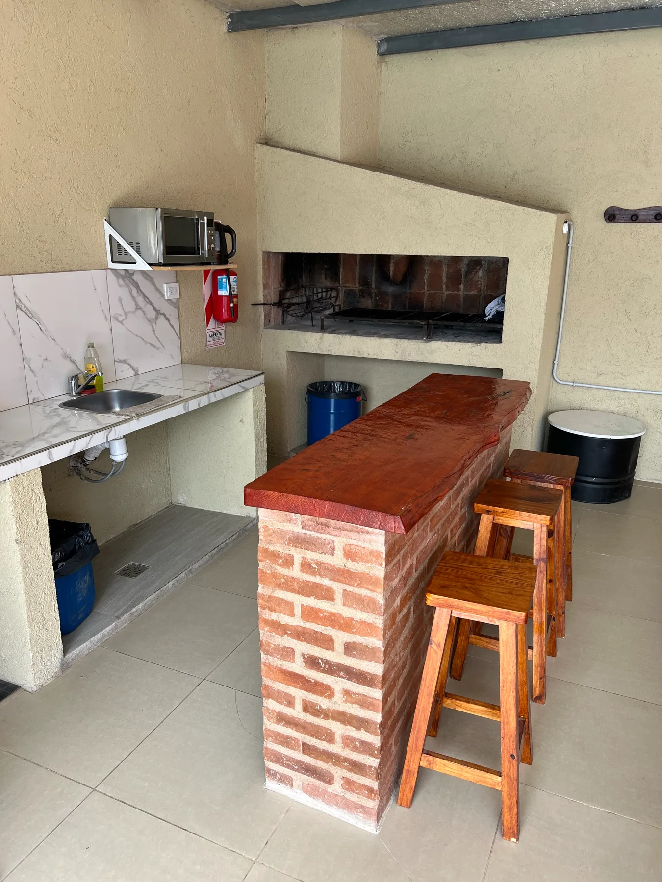 Barra de madera frente al asador y la cocina