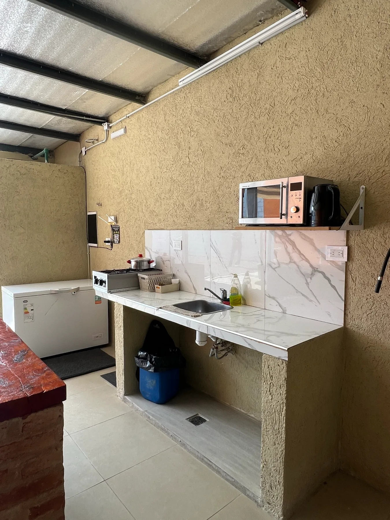 Cocina con mesada, microondas y freezer