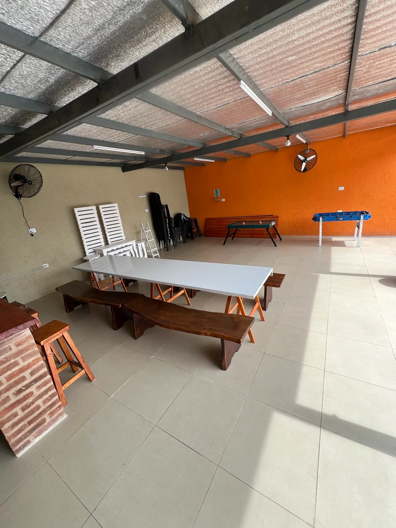 Salón cubierto con tablones, bancas y juegos